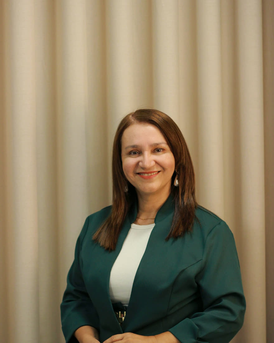 Portrait of Alexandra Reyes, nurse practitioner, in a deep green blazer